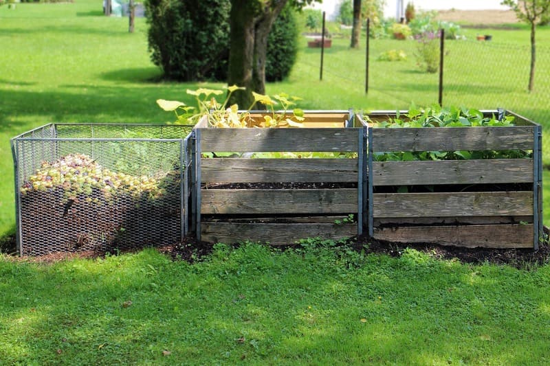 3 bacs à compost dans un jardin collectif
